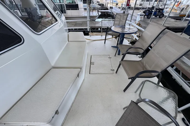 Slide: The Image of 1993 Gibson 44 Cabin Yacht deck with seating and table, docked at marina. - 6