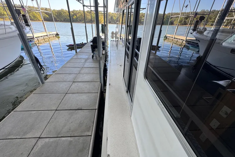 Slide: The Image of 1993 Gibson 44 Cabin Yacht docked beside a tiled walkway on a sunny day. - 7