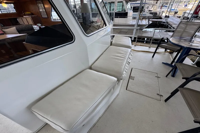 Slide: The Image of 1993 Gibson 44 Cabin Yacht interior with cushioned seating and marina view. - 8