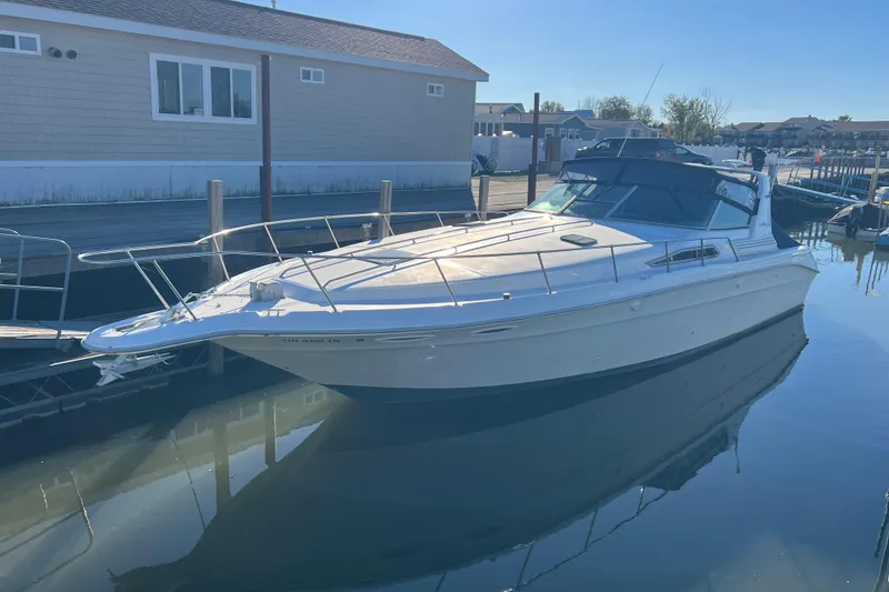 The Image of 1991 Sea Ray 400 Express Cruiser docked at marina under clear blue sky. - 0
