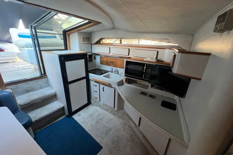Slide: The Image of 1991 Sea Ray 400 Express Cruiser interior with kitchenette, fridge, and microwave. - 10