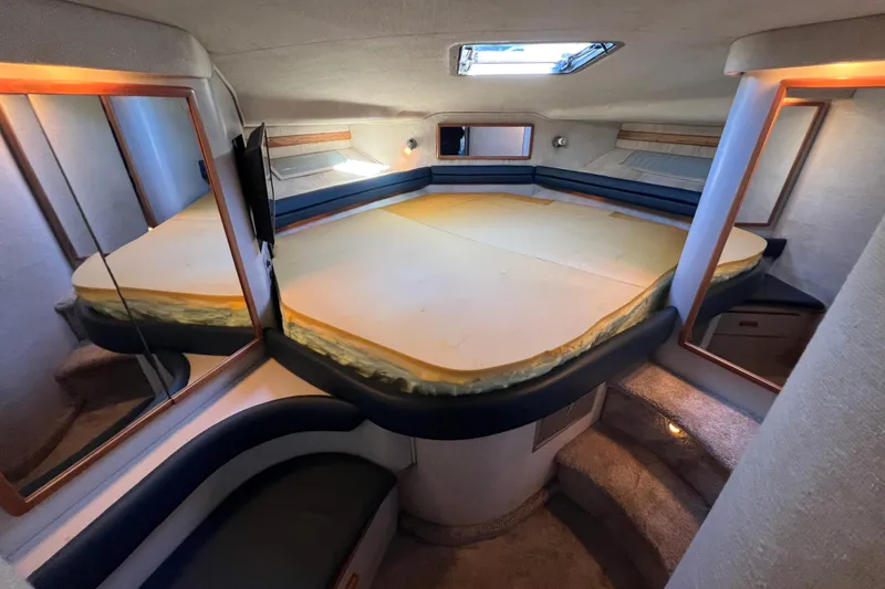 Slide: The Image of 1991 Sea Ray 400 Express Cruiser interior cabin with bed, mirrors, and skylight. - 14