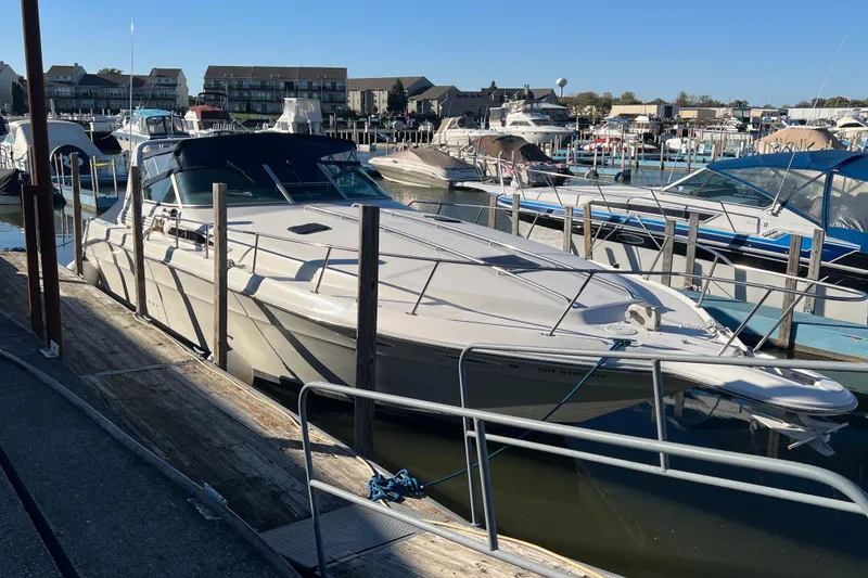 Slide: The Image of 1991 Sea Ray 400 Express Cruiser docked at marina under clear blue sky. - 2