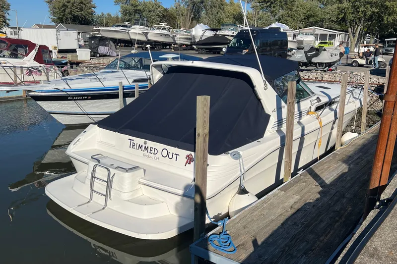 Slide: The Image of 1991 Sea Ray 400 Express Cruiser docked, covered, with "Trimmed Out" name visible. - 3