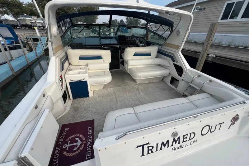 Slide: The Image of 1991 Sea Ray 400 Express Cruiser interior with white seating, docked at marina. - 4