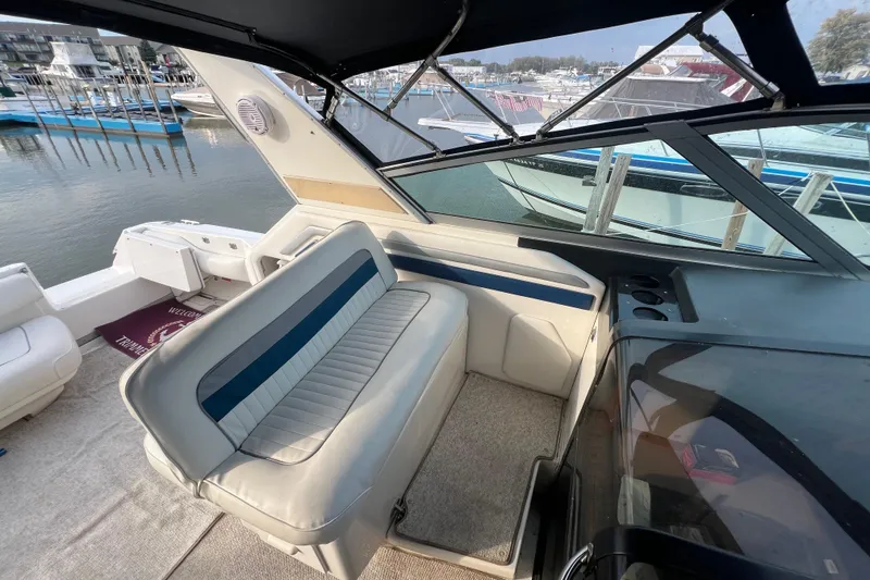 Slide: The Image of 1991 Sea Ray 400 Express Cruiser interior with seating, docked at marina. - 6