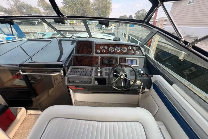 Slide: The Image of 1991 Sea Ray 400 Express Cruiser helm with steering wheel and control panel. - 7
