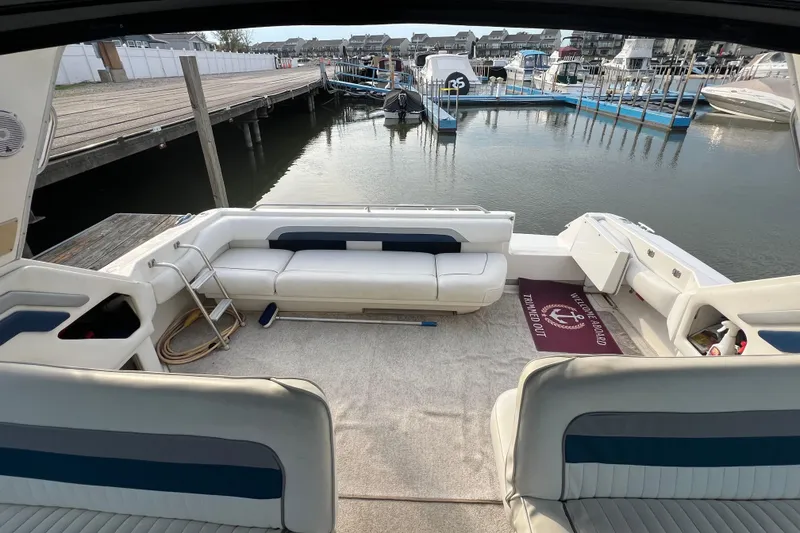 Slide: The Image of 1991 Sea Ray 400 Express Cruiser interior with white seating, docked at marina. - 8