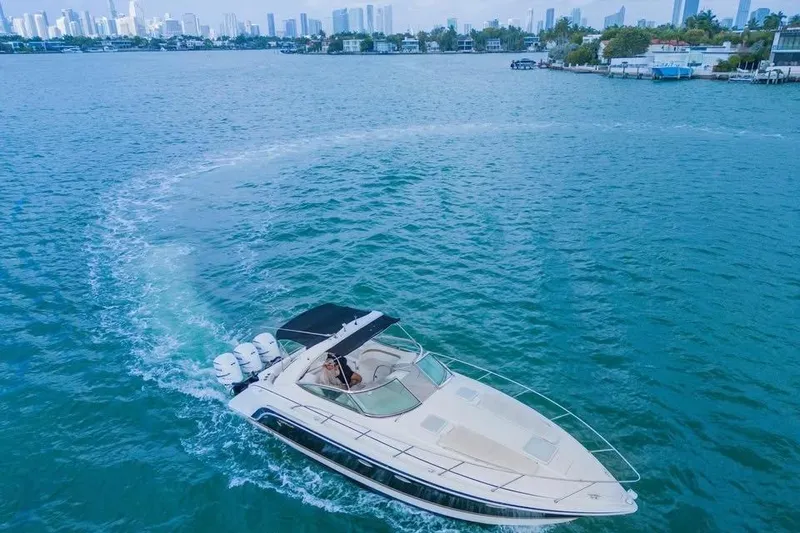 Slide: The Image of 2003 Formula 34 Performance Cruiser navigating blue waters near city skyline. - 3