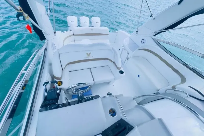 Slide: The Image of 2003 Formula 34 Performance Cruiser interior with white seating and helm, on blue water. - 5