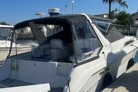 Slide: The Image of 1990 Sea Ray 310 Sundancer boat docked under clear blue sky. - 4