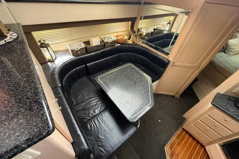 Slide: The Image of Luxurious interior of 1999 Carver 406 Aft Cabin Motor Yacht with black leather seating. - 17