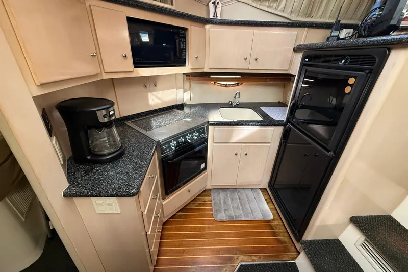 Slide: The Image of 1999 Carver 406 Aft Cabin Motor Yacht kitchen with appliances and wooden flooring. - 19