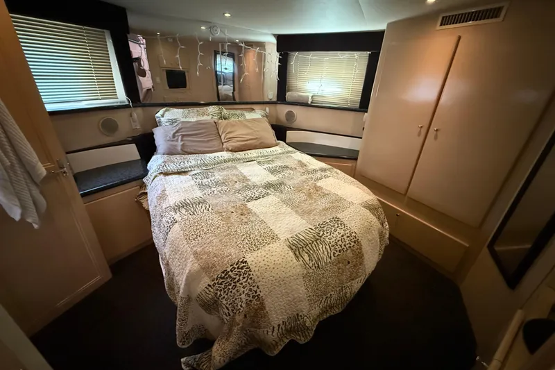Slide: The Image of Cozy bedroom in 1999 Carver 406 Aft Cabin Motor Yacht with patterned bedding and ambient lighting. - 23