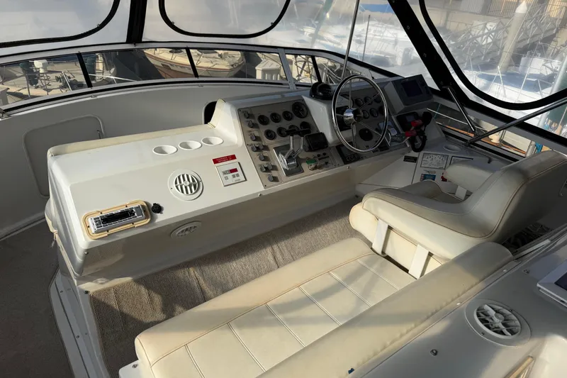 Slide: The Image of 1999 Carver 406 Aft Cabin Motor Yacht helm with steering wheel and control panel. - 8
