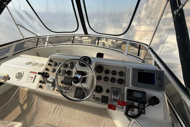 Slide: The Image of 1999 Carver 406 Aft Cabin Motor Yacht helm with navigation instruments and steering wheel. - 9