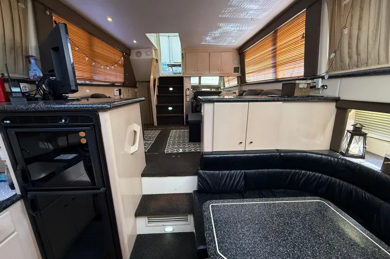 Slide: The Image of Interior of 1999 Carver 406 Aft Cabin Motor Yacht with modern furnishings and cozy seating. - 14