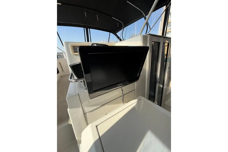 Slide: The Image of 1999 Carver 406 Aft Cabin Motor Yacht interior with mounted TV and modern design. - 7