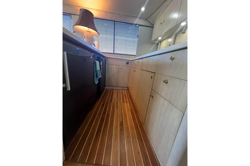 Slide: The Image of 1996 Ocean Yachts 48 Super Sport kitchen with modern appliances and wooden cabinetry. - 14