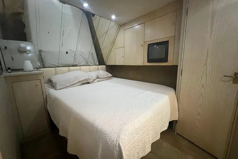 Slide: The Image of 1996 Ocean Yachts 48 Super Sport bedroom with white bedding and modern decor. - 22