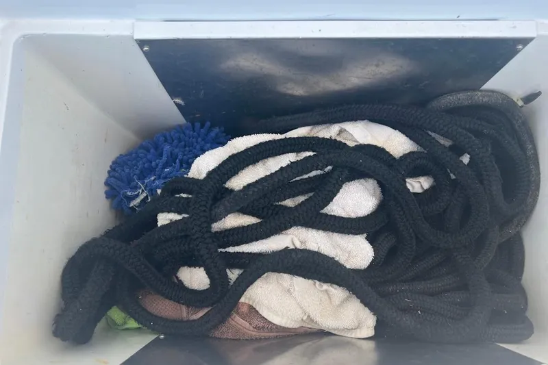 Slide: The Image of Storage compartment with black rope and cleaning cloths on a 1996 Ocean Yachts 48 Super Sport. - 46