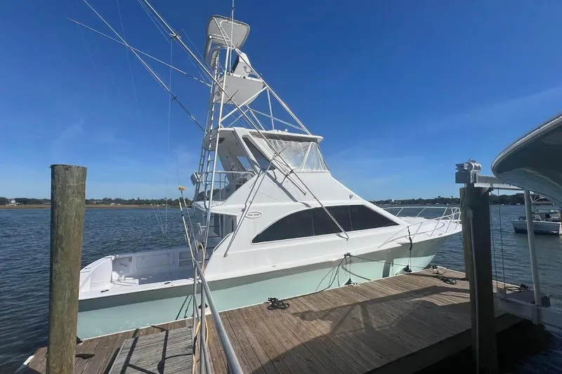 Slide: The Image of 1996 Ocean Yachts 48 Super Sport docked by the water on a sunny day. - 53