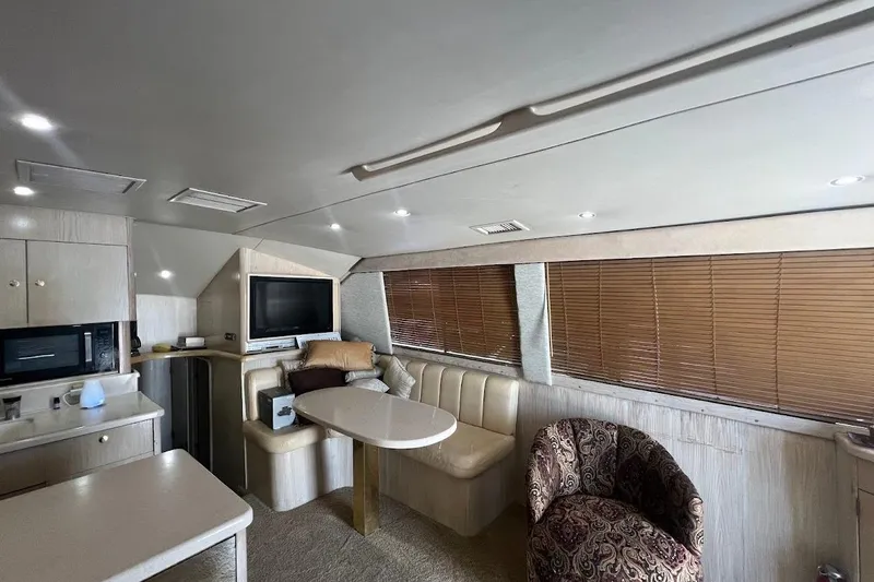 Slide: The Image of Interior of 1996 Ocean Yachts 48 Super Sport with seating, table, and kitchenette. - 8