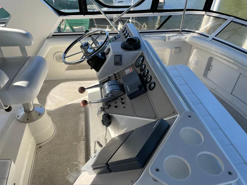 Slide: The Image of 1998 Carver 445 Aft Cabin Motor Yacht helm with steering wheel and control panel. - 14
