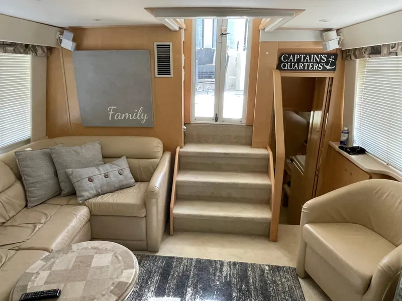 Slide: The Image of 1998 Carver 445 Aft Cabin Motor Yacht interior with cozy seating and "Captain's Quarters" sign. - 22