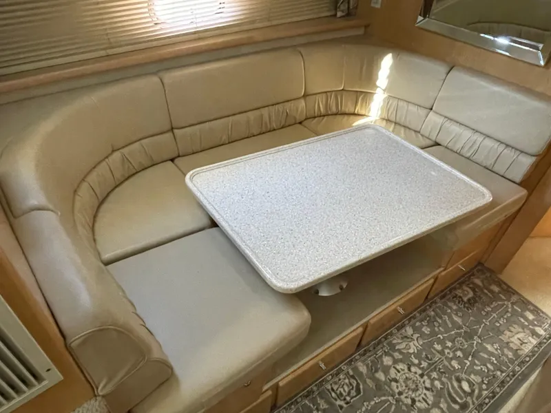 Slide: The Image of 1998 Carver 445 Aft Cabin Motor Yacht interior with beige seating and table. - 29