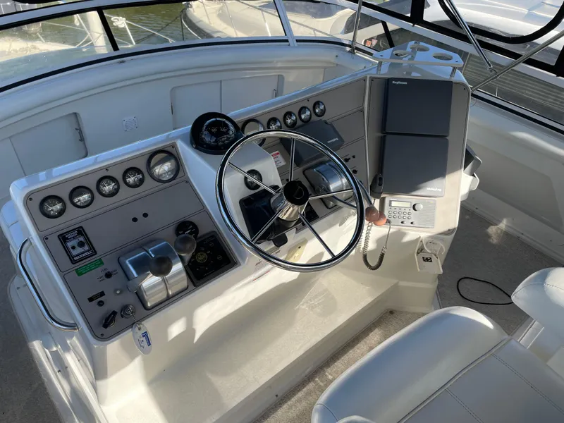 Slide: The Image of 1998 Carver 445 Aft Cabin Motor Yacht helm with steering wheel and control panel. - 12