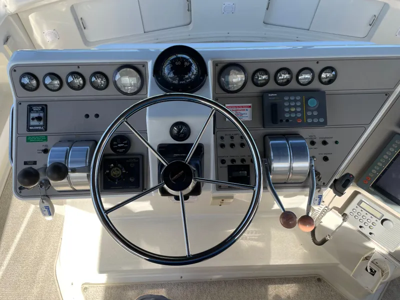 Slide: The Image of 1998 Carver 445 Aft Cabin Motor Yacht helm with steering wheel and control panel. - 13