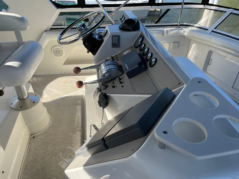 Slide: The Image of 1998 Carver 445 Aft Cabin Motor Yacht helm with controls and seating. - 16