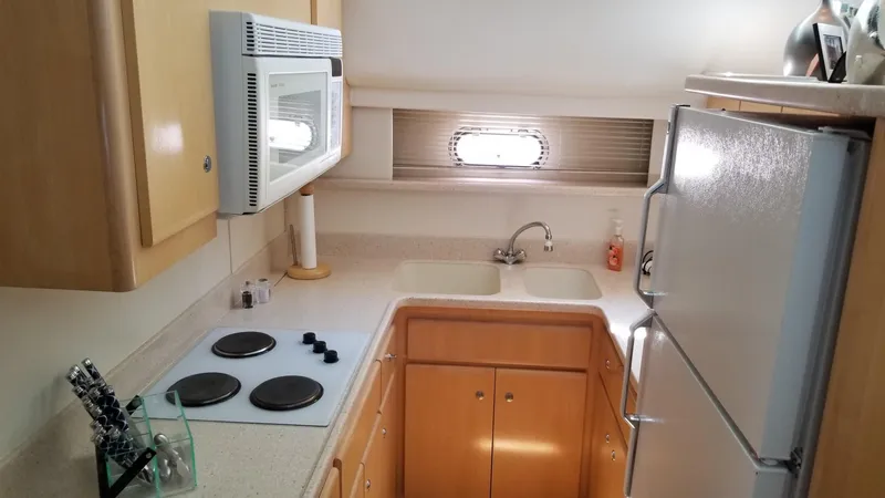 Slide: The Image of 1998 Carver 445 Aft Cabin Motor Yacht kitchen with stove, microwave, and fridge. - 30