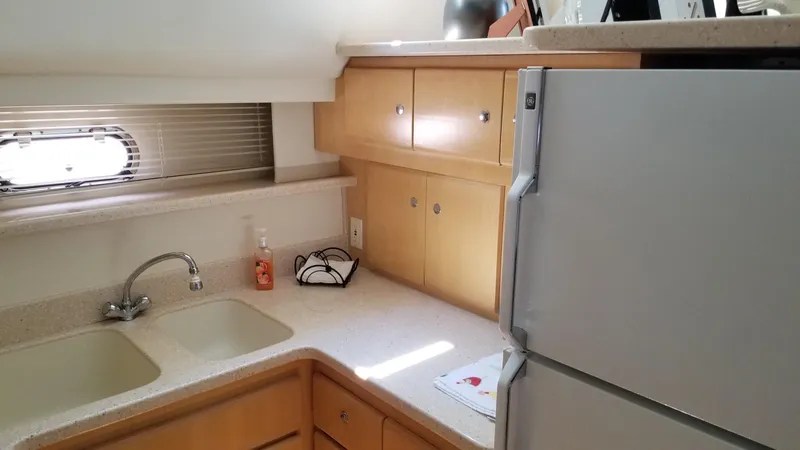 Slide: The Image of 1998 Carver 445 Aft Cabin Motor Yacht kitchen with sink, cabinets, and refrigerator. - 31