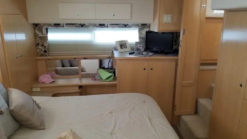 Slide: The Image of Interior of 1998 Carver 445 Aft Cabin Motor Yacht bedroom with bed, cabinets, and TV. - 38