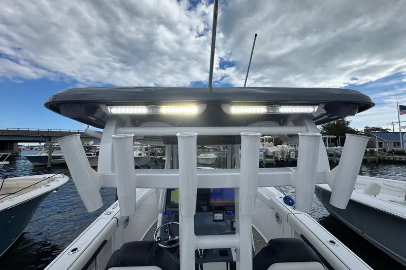 Slide: The Image of 2025 Tidewater 302 CC Adventure boat with rod holders and LED lights at a marina. - 100