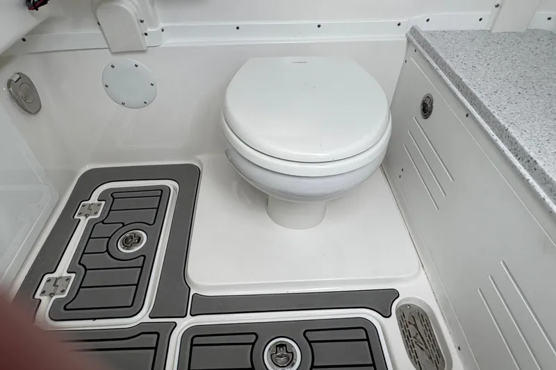 Slide: The Image of 2025 Tidewater 302 CC Adventure boat bathroom with toilet and non-slip flooring. - 104