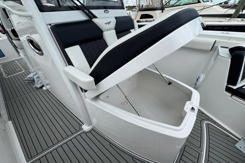 Slide: The Image of 2025 Tidewater 302 CC Adventure boat with open storage compartment and sleek seating design. - 111