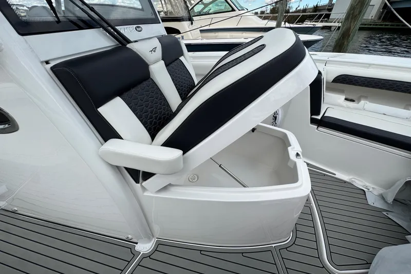 Slide: The Image of 2025 Tidewater 302 CC Adventure boat seat with storage compartment open. - 112