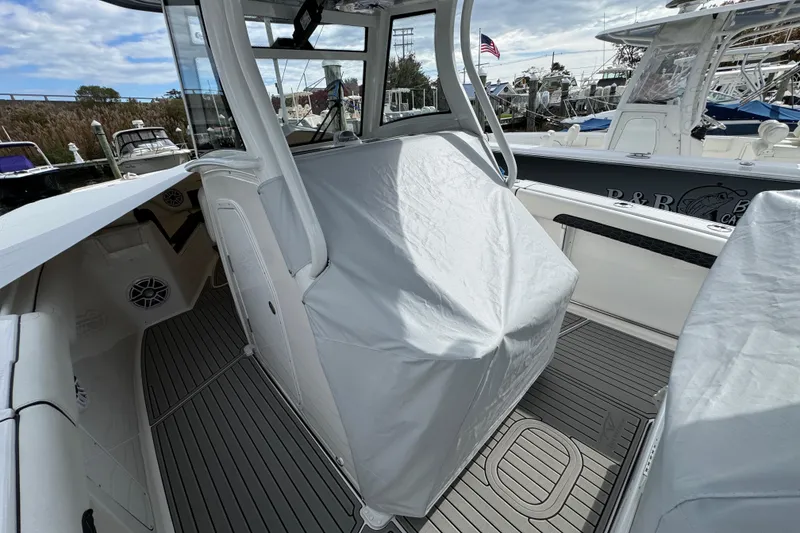 Slide: The Image of 2025 Tidewater 302 CC Adventure boat interior with covered console, docked in marina. - 115