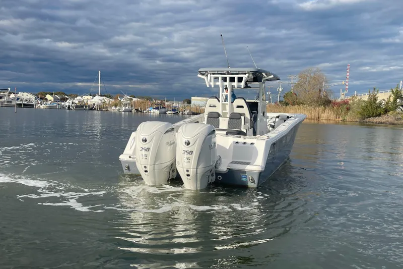 Slide: The Image of 2025 Tidewater 302 CC Adventure boat with dual engines on calm water. - 14