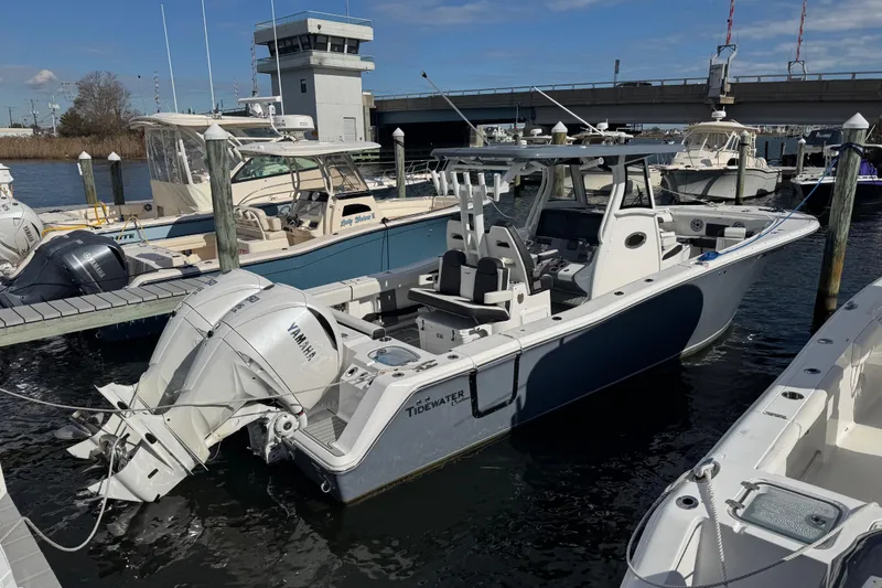 Slide: The Image of 2025 Tidewater 302 CC Adventure boat docked, featuring Yamaha engines, in a marina setting. - 18