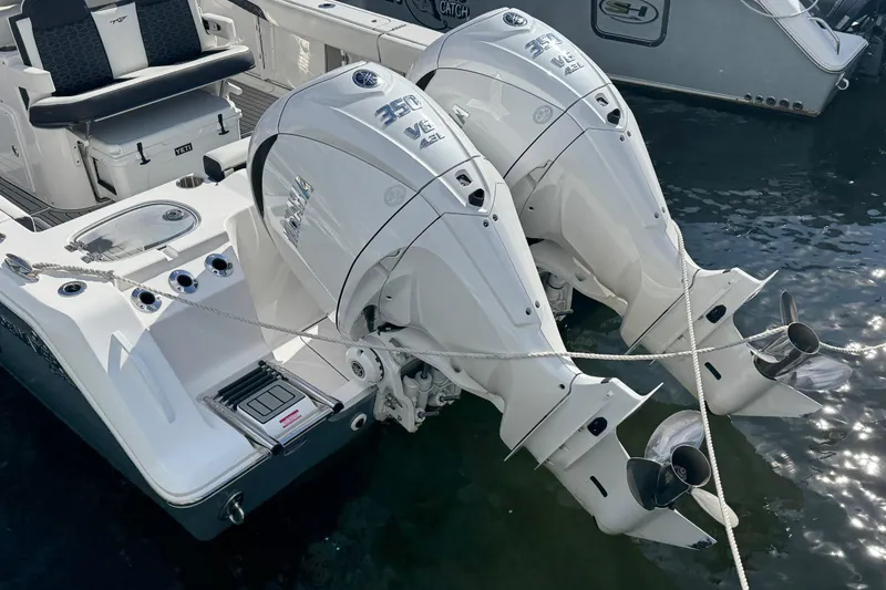 Slide: The Image of 2025 Tidewater 302 CC Adventure boat with dual outboard engines docked in water. - 21