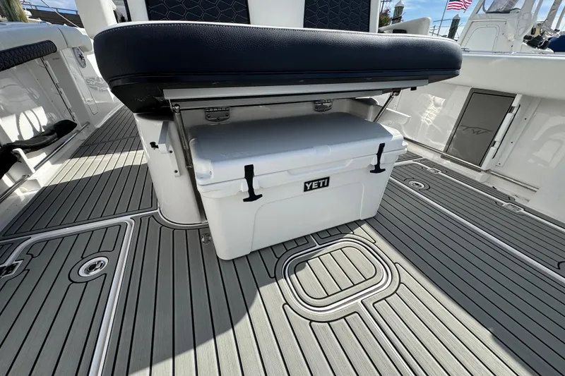 Slide: The Image of 2025 Tidewater 302 CC Adventure boat with Yeti cooler under seat on deck. - 23