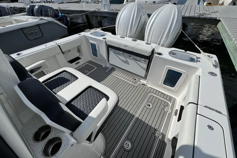 Slide: The Image of 2025 Tidewater 302 CC Adventure boat interior with seating and deck at marina. - 24