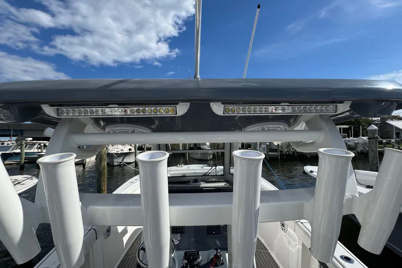 Slide: The Image of 2025 Tidewater 302 CC Adventure boat with rod holders and LED lights, docked under blue sky. - 31