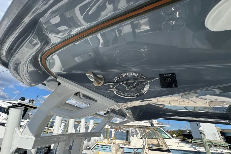 Slide: The Image of 2025 Tidewater 302 CC Adventure boat detail, showcasing sleek design and logo. - 33