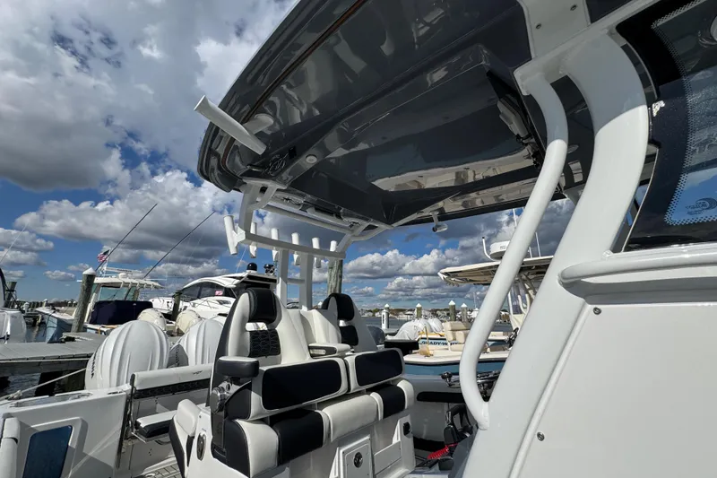 Slide: The Image of 2025 Tidewater 302 CC Adventure boat interior at marina, under cloudy sky. - 34