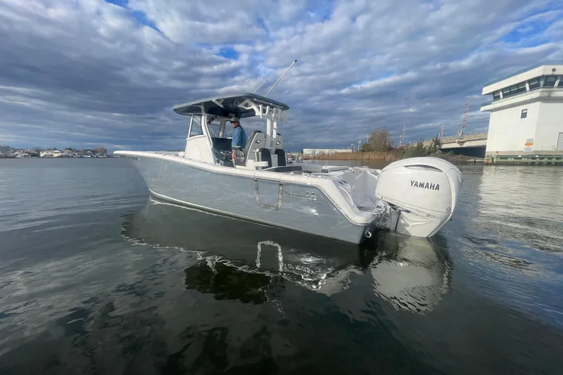 Slide: The Image of 2025 Tidewater 302 CC Adventure boat on calm water with Yamaha engine. - 4